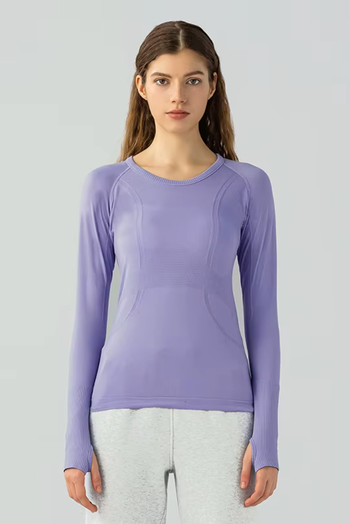 Woman wearing a purple long-sleeve top against a light gray background